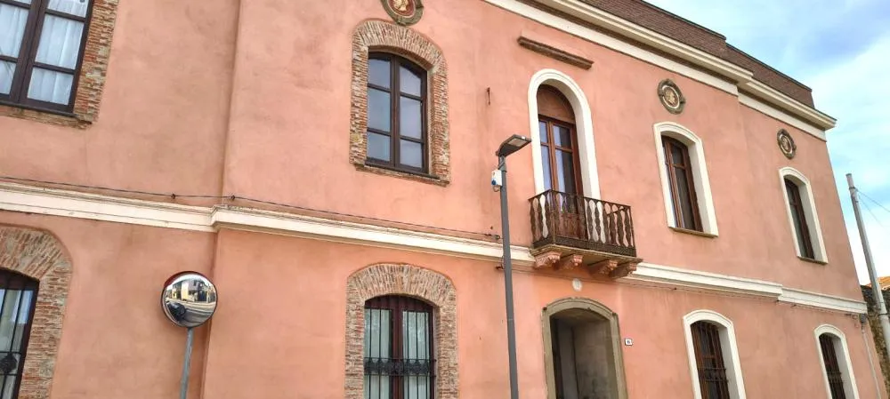 Palazzetto colore rosa com finestre e balcone
